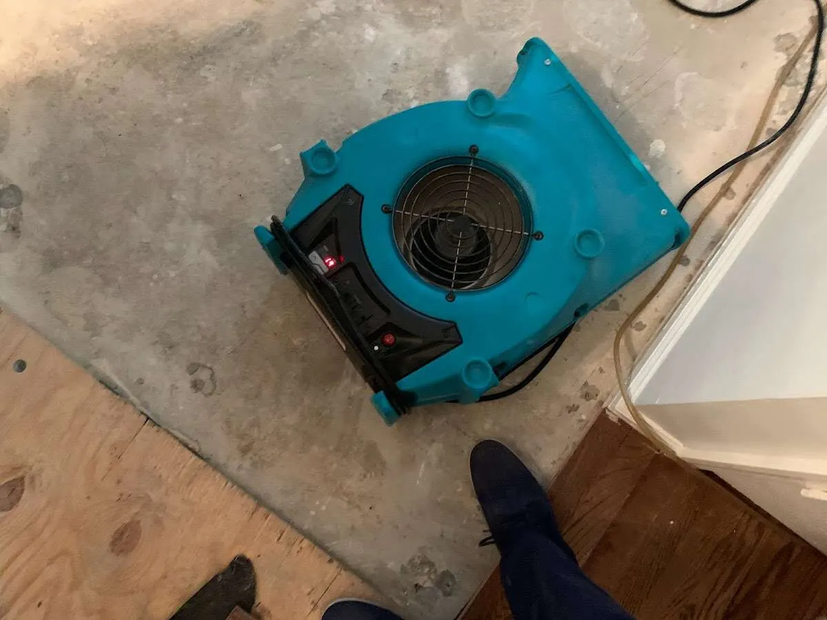 Air mover drying subfloor during Commercial Water Damage Restoration in Conroe